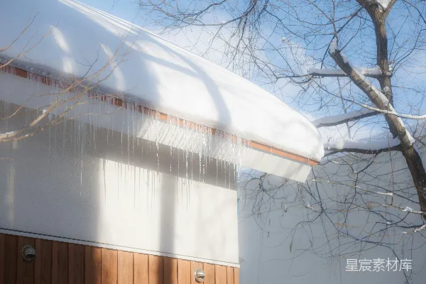 高清摄影 冰锥从覆盖着雪的屋顶垂下