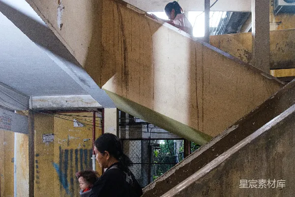 高清摄影 一位带着婴儿和孩子的女人站在混凝土台阶上。