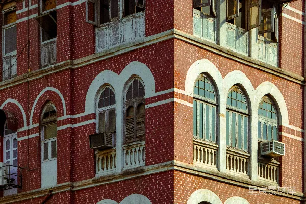 高清摄影 一座古老的红砖建筑，带有拱形窗户和阳台。
