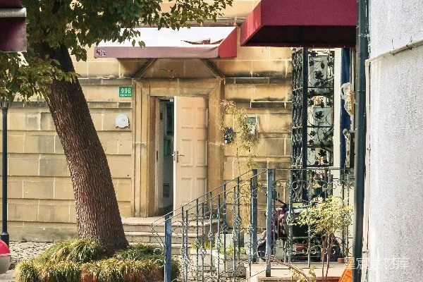 高清摄影 建筑物外的鹅卵石小径上，有树和盆栽植物。