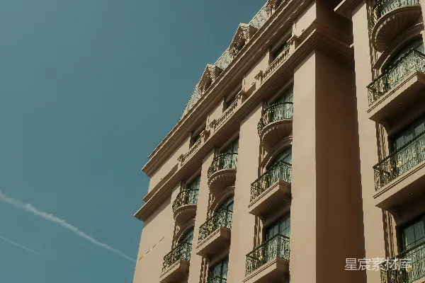 高清摄影 装饰性的米色建筑，带有阳台，背景是蓝天。