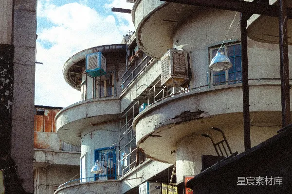 高清摄影 旧的、斑驳的建筑物，带有圆形阳台，在多云的天空下。