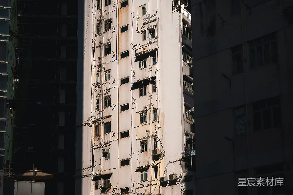 高清摄影 高而窄的白色建筑被深色的建筑包围。