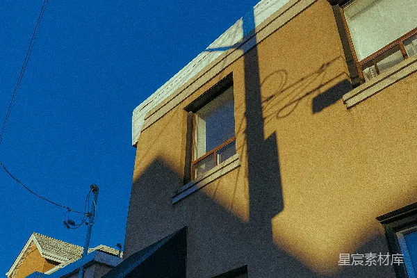 高清摄影 棕色建筑在明亮的蓝天背景下，窗户清晰可见。