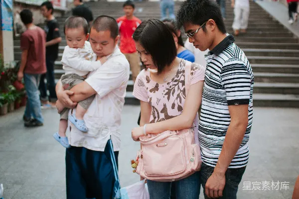 高清摄影 一个男人抱着一个婴儿，一对夫妇低头看着。