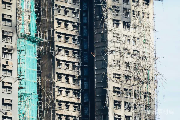 高清摄影 摩天大楼被火灾损坏，有脚手架和安全网。