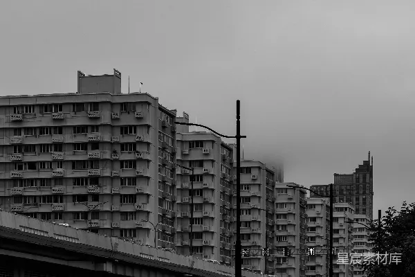 高清摄影 一排高耸的公寓大楼在阴云密布的单色天空下。