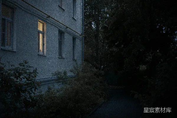 高清摄影 夜晚黑暗的建筑物中一扇亮着的窗户。