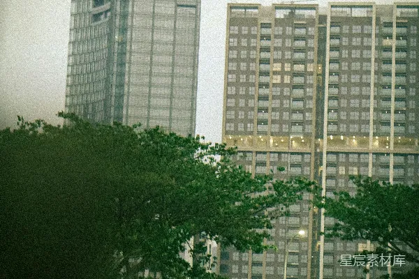 高清摄影 城市建筑被绿色植物环绕，旁边有一辆车。