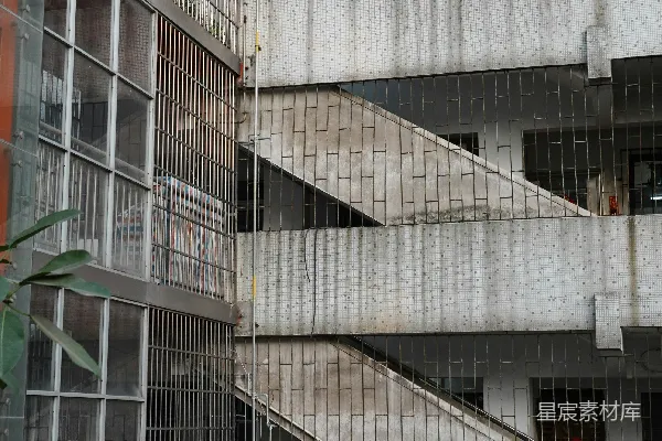 高清摄影 混凝土楼梯沿着一座风化的建筑外墙向上延伸。