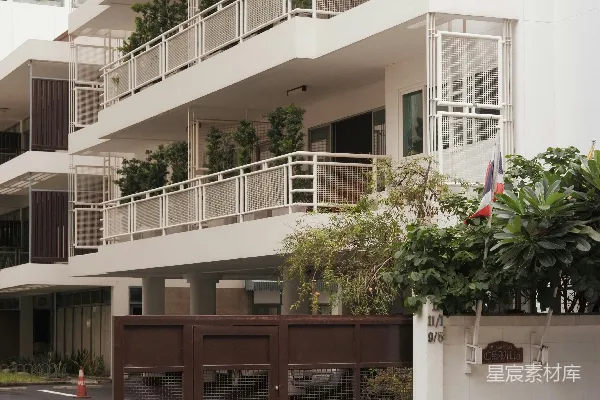 高清摄影 白色现代化建筑，有阳台，棕色大门，以及架设的电线。