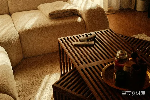 高清摄影 阳光洒满的客厅，配有米色沙发和木质咖啡桌。
