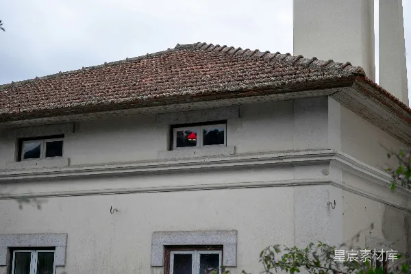 高清摄影 在建筑物的窗户里可以看到一个红色的物体。