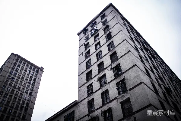 高清摄影 两栋高大的旧建筑在明亮的天空下。