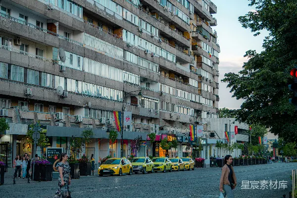 高清摄影 城市街道上有一座高大的建筑和几辆黄色出租车。