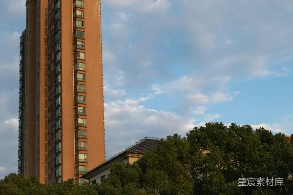 高清摄影 高大的棕色建筑在绿树和蓝天之间。