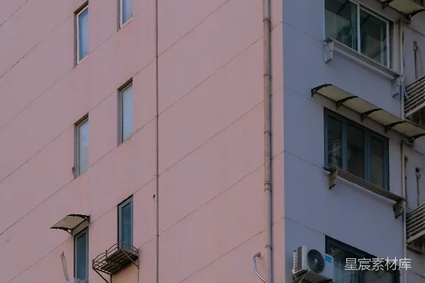 高清摄影 城市建筑的外墙，有许多窗户和空调。