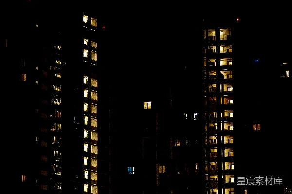 高清摄影 夜晚灯光照亮的公寓楼，窗户闪烁着光亮。
