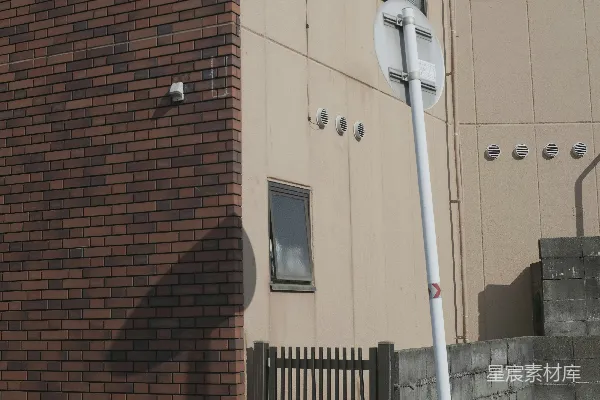 高清摄影 一座砖砌建筑旁边倾斜的路标