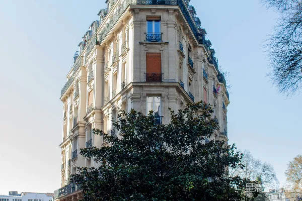 高清摄影 街角处有一座三角形建筑，周围有树木。
