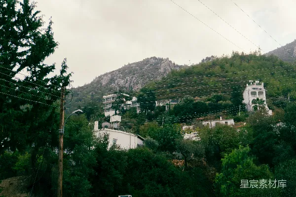 高清摄影 建筑物坐落在绿意盎然的山坡上，山峦环绕。