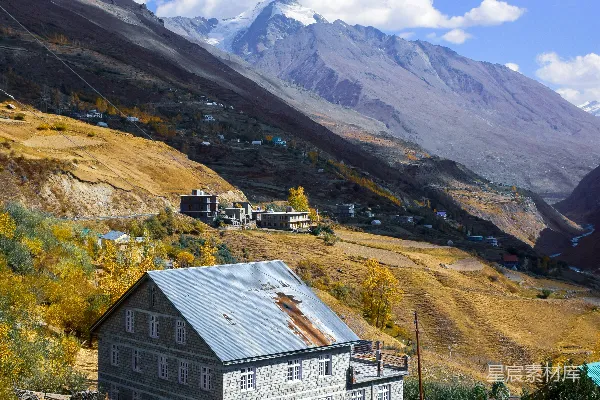 高清摄影 山间谷地中的石屋，秋季树叶环绕。