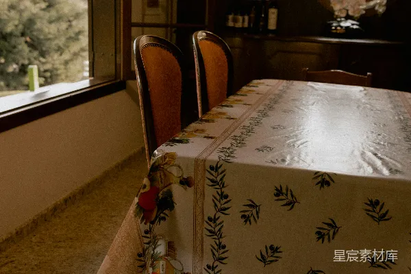 高清摄影 餐桌铺有图案桌布，旁边有拱形窗户。
