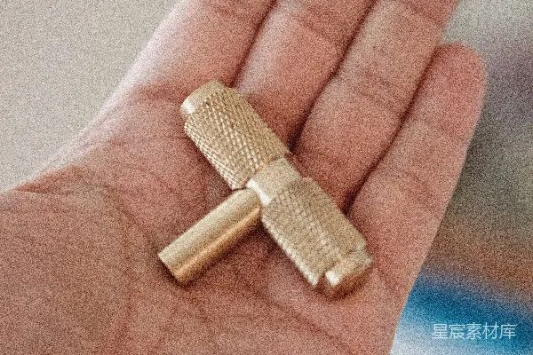高清摄影 一个人手里拿着一个小金物体。