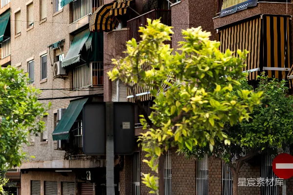 高清摄影 街景，包括建筑物、树木和户外咖啡馆的座位。