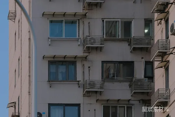 高清摄影 城市公寓建筑外立面，有许多窗户和空调。