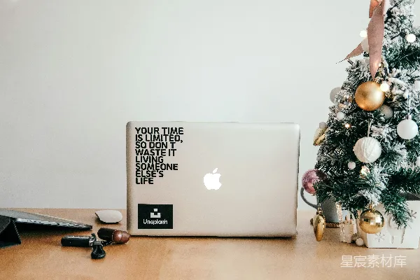 高清摄影 银色的MacBook旁边放着一副黑框眼镜，放在棕色的木桌上。