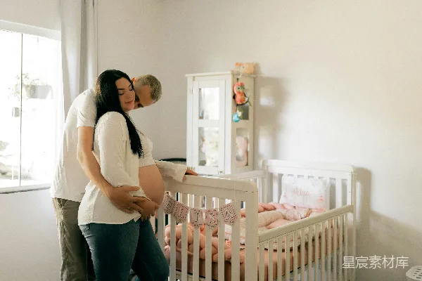 高清摄影 一对夫妇在婴儿床旁边抱着婴儿。