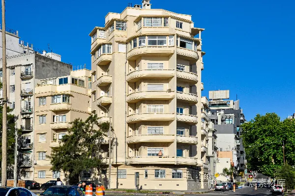 高清摄影 一座高大的奶油色建筑，下方有阳台，在蓝天映衬下。
