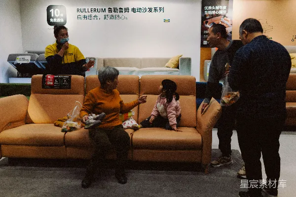 高清摄影 人们围坐在展示厅的一张沙发旁。