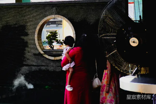 高清摄影 女人抱着孩子，透过圆形的窗户向外看。