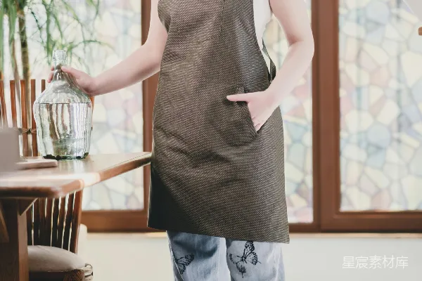 高清摄影 一个穿着围裙的女人拿着一个鸟笼