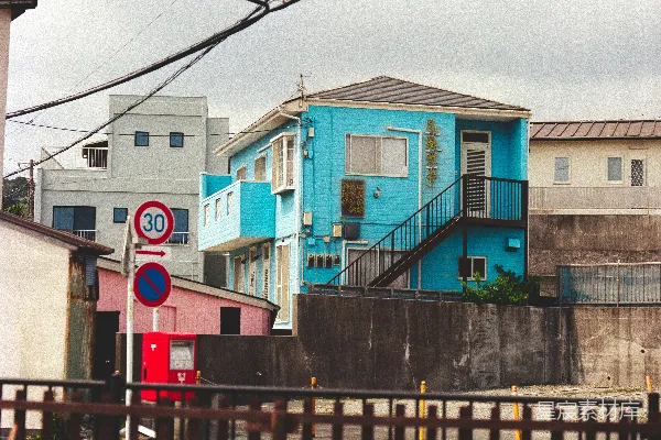 高清摄影 明亮的蓝色建筑，带有楼梯和街道标志。