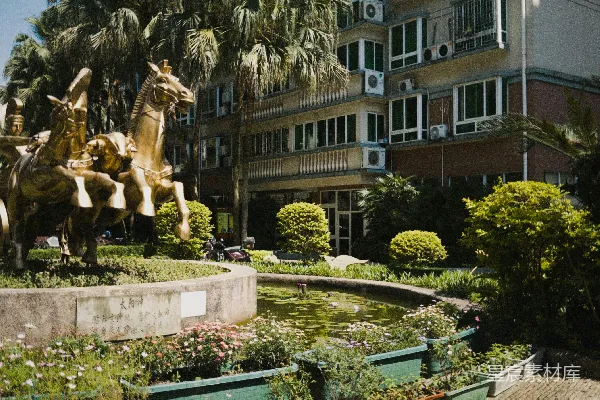 高清摄影 花园中有一座青铜战车雕塑，旁边有一座建筑。