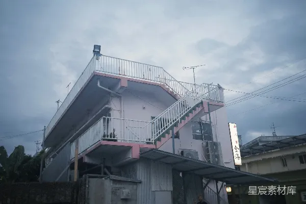 高清摄影 一座淡粉色的建筑，外面有楼梯。