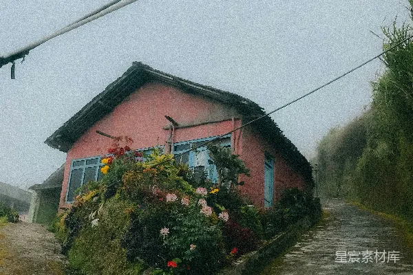 高清摄影 一幢粉红色的房子，旁边开满了花。