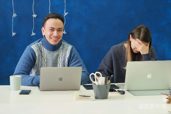 高清摄影 穿着灰色毛衣的女人正在使用银色的MacBook。