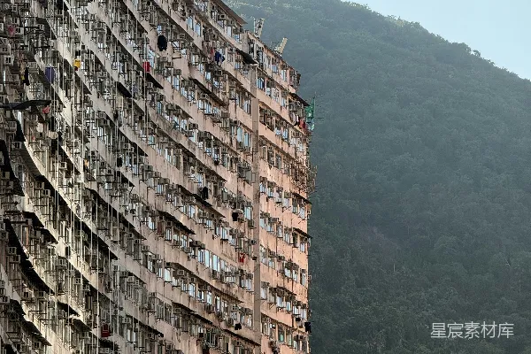 高清摄影 密集的公寓楼矗立在郁郁葱葱的青山前。