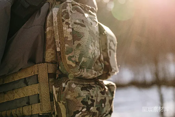 高清摄影 穿着迷彩服的士兵背着战术背包在冬林中。
