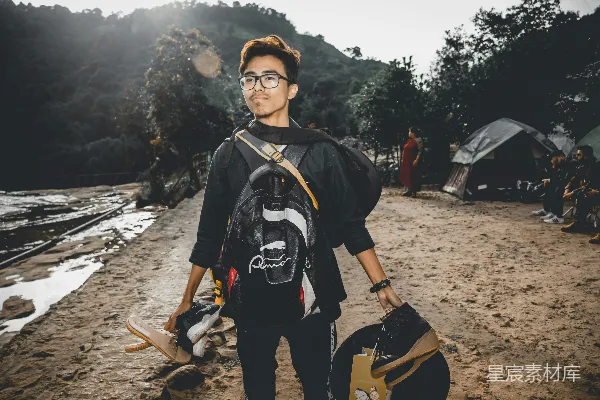 高清摄影 一个背着黑色背包的男人站在海岸上。