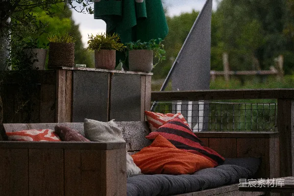 高清摄影 户外木质沙发，配有彩色靠垫和条纹靠垫。