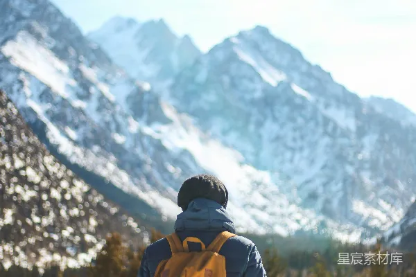 高清摄影 站着的人拿着雪杖面对着山。