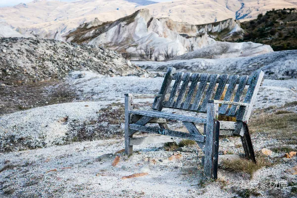 高清摄影 白昼时分，棕色的木制长椅放置在白雪覆盖的地面上。