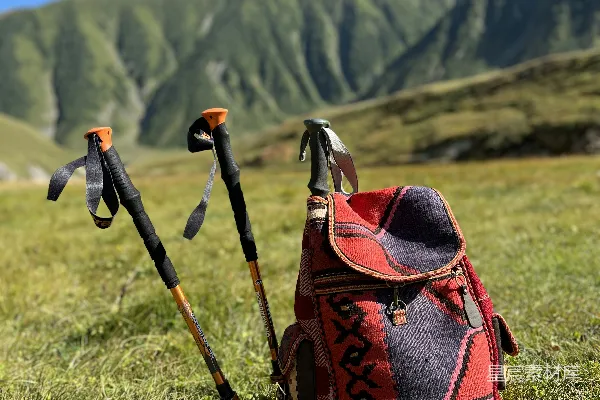 高清摄影 一双徒步登山杖和一个背包放在草地上