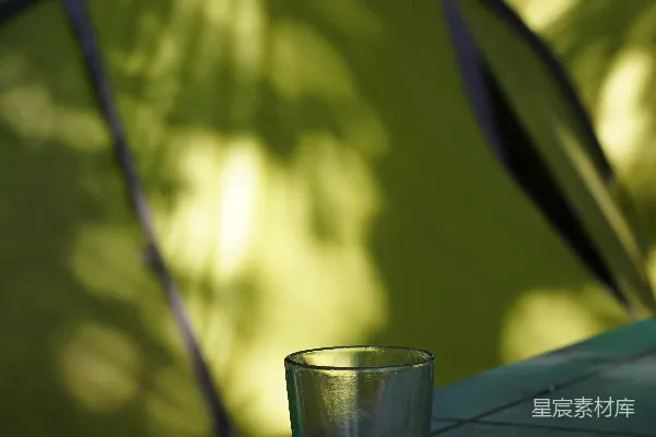 高清摄影 一个酒杯放在帐篷前的桌子上。