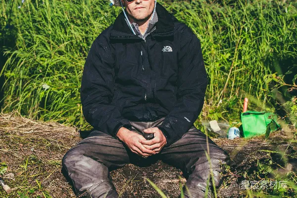 高清摄影 穿黑色夹克和黑色裤子的男人坐在棕色岩石上。